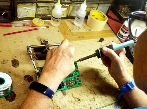 technician soldering on circuit board